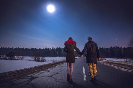 Young couple watching beautiful starry sky on full moon night.の写真素材