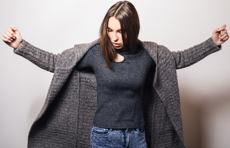 Beautiful young girl in gray coat posing in studio.の写真素材