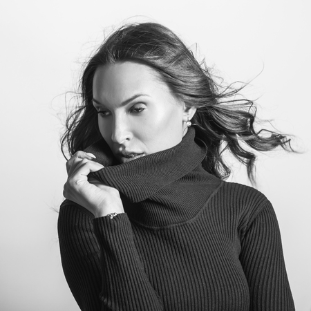 Beautiful girl in stylish black dress posing in studio. Black-white portrait.の写真素材
