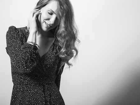 Beautiful girl in stylish dress posing in studio. Black-white photo, blurの写真素材