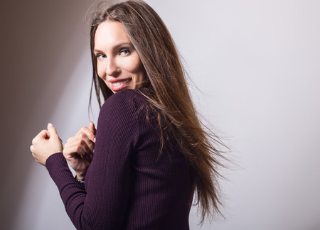 Beautiful young girl in violet golf posing in studio.の写真素材