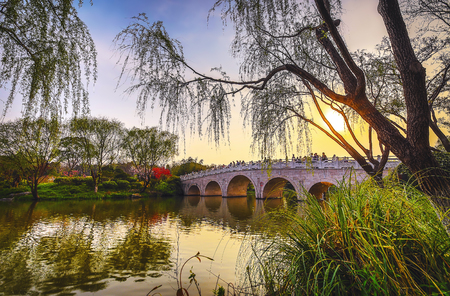 Old traditional Chinese bridge in city park.の写真素材