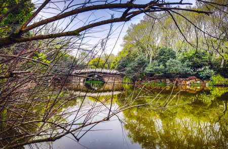 Old traditional Chinese bridge in city park.
