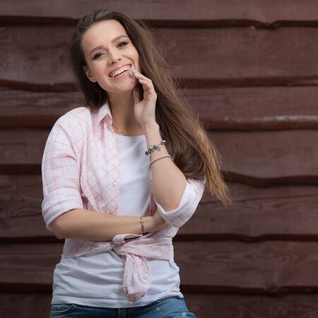 Portrait of beautiful young girl on wooden background.の写真素材