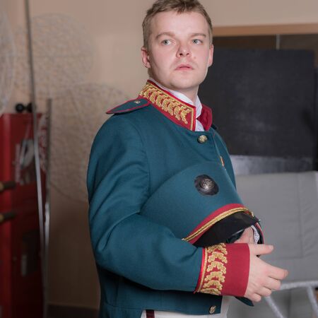 Actor dressed historical costume in interior of old theater.