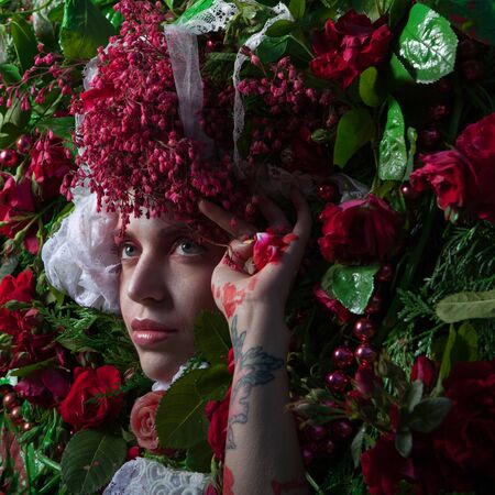 Female portrait in fairy tale stylization surrounded with natural flowers.の写真素材