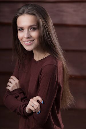 Portrait of beautiful young girl on wooden background.の写真素材