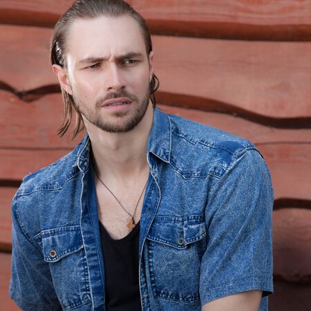 Portrait of handsome young man on wooden background.の写真素材