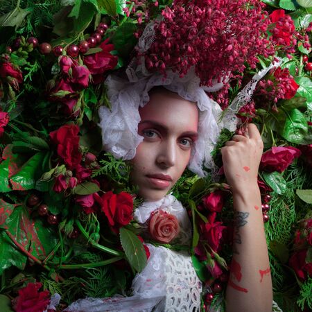 Female portrait in fairy tale stylization surrounded with natural flowers.の写真素材