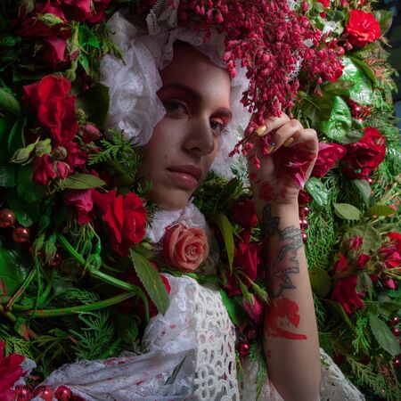 Female portrait in fairy tale stylization surrounded with natural flowers.の写真素材