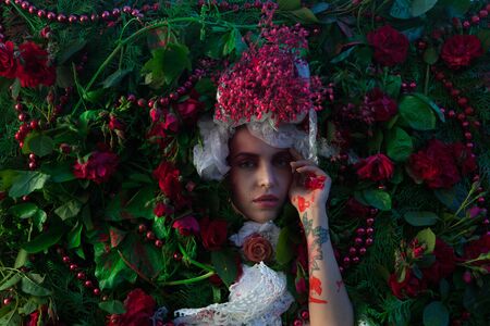 Female portrait in fairy tale stylization surrounded with natural flowers.の写真素材