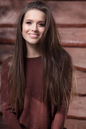 Portrait of beautiful young girl on wooden background.の写真素材