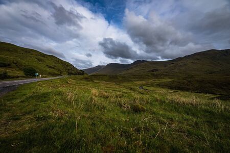 Beautiful scenic landscape of amazing Scotland nature and mountain trail road.の写真素材