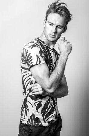 Elegant young handsome man in stylish T-shirt. Black-white photo.の写真素材