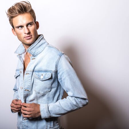 Handsome young man in jeans jacket pose in studio.の写真素材