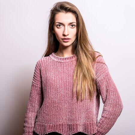 Young model woman in sweater pose in studio.の写真素材