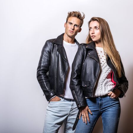 Young beautiful couple in black leather jackets pose in studio.の写真素材