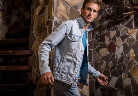 Young handsome man model against natural stone background.の写真素材