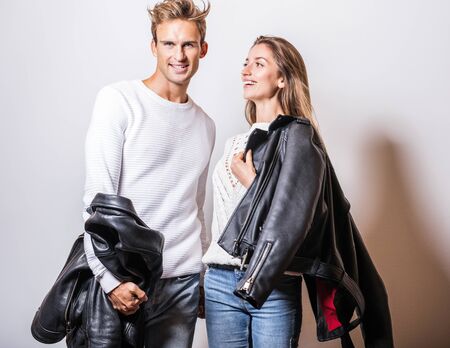 Young beautiful couple in black leather jackets pose in studio.の写真素材