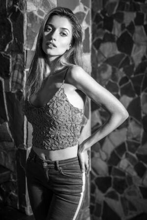 Young beauty woman against natural stone background. Black-white portrait.の写真素材