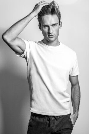Elegant young handsome man in stylish T-shirt. Black-white photo.の写真素材