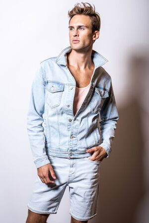Handsome young man in jeans jacket pose in studio.の写真素材