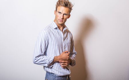 Elegant young handsome man in stylish blue shirt.の写真素材