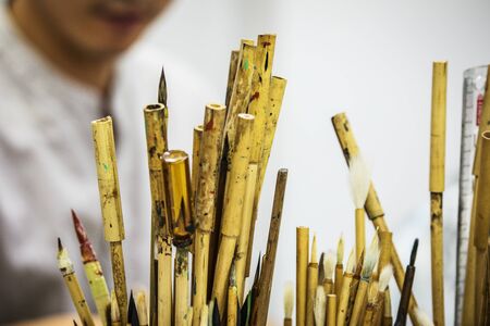 BEIJING, Ð¡HINA - JUNE 03: Chinese craftsman paints a large porcelain vase with traditional tassels. Master hands close-up.のeditorial素材