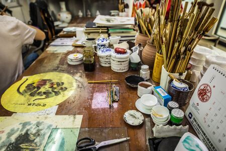 BEIJING, Ð¡HINA - JUNE 03: Chinese craftsman paints a large porcelain vase with traditional tassels. Master hands close-up.のeditorial素材