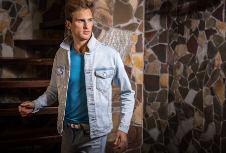 Young handsome man model against natural stone background.の写真素材