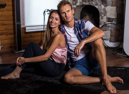 Young and beautiful happy family together in modern wooden house interior.の写真素材