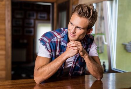 Handsome young man in in casual clothes pose against house interior.の写真素材