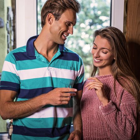 Young and beautiful happy family together in modern wooden house interior.の写真素材