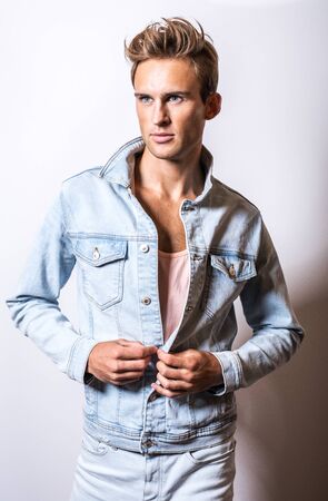 Handsome young man in jeans jacket pose in studio.の写真素材