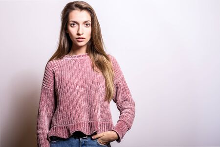 Young model woman in sweater pose in studio.の写真素材