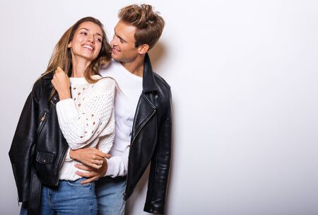 Young beautiful couple in black leather jackets pose in studio.の写真素材
