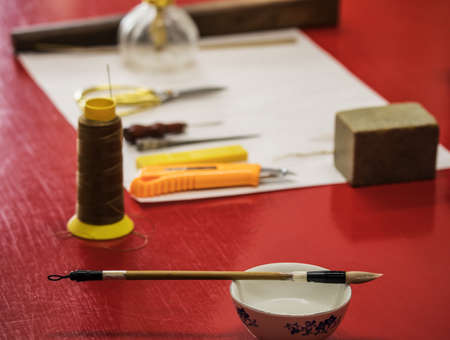BEIJING, Ð¡HINA - JUNE 01, 2019: Traditional Chinese book and calligraphy restorer laboratory. Master hands at work close-up.のeditorial素材
