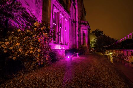 Multi-colored night lighting of the Scottish house gardenの写真素材