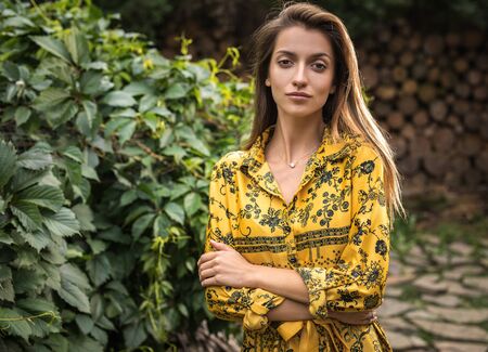 Beautiful emotional outdoor portrait of young woman in yellow dress.の写真素材