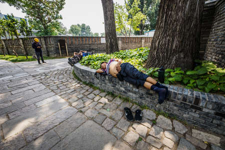 BEIJING, Ð¡HINA - JUNE 01, 2019: Chinese working man sleeping at city park.のeditorial素材