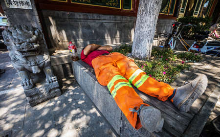 BEIJING, Ð¡HINA - JUNE 01, 2019: Chinese working man sleeping at city park.のeditorial素材