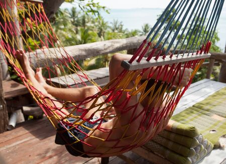 Relaxed attractive young man against tropical landscape.