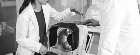 Doctors hands close-up against modern health diagnostic equipment.