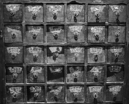 Chinese vintage pharmacy cabinet as background black-white photo.