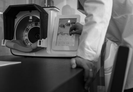 Doctors hands close-up against modern health diagnostic equipment.の写真素材