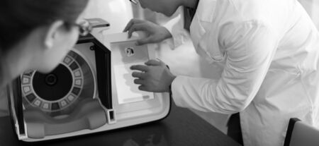 Doctors hands close-up against modern health diagnostic equipment.の写真素材