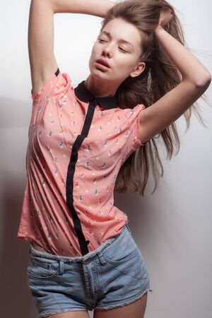 Young beautiful stylish girl posing in studio.の写真素材