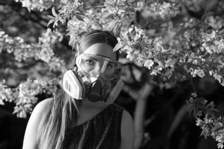 Young beautiful girl portrait in a mask with degree of protection posing in twilight of spring...