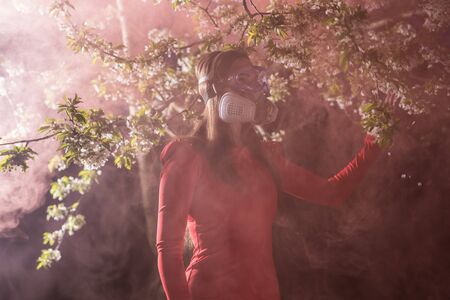 Young beautiful girl portrait in a mask with degree of protection posing in twilight of spring...