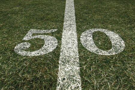Friday Night Lights Football Game on Football field fifty yard line background. An American football grass turf football field.の写真素材
